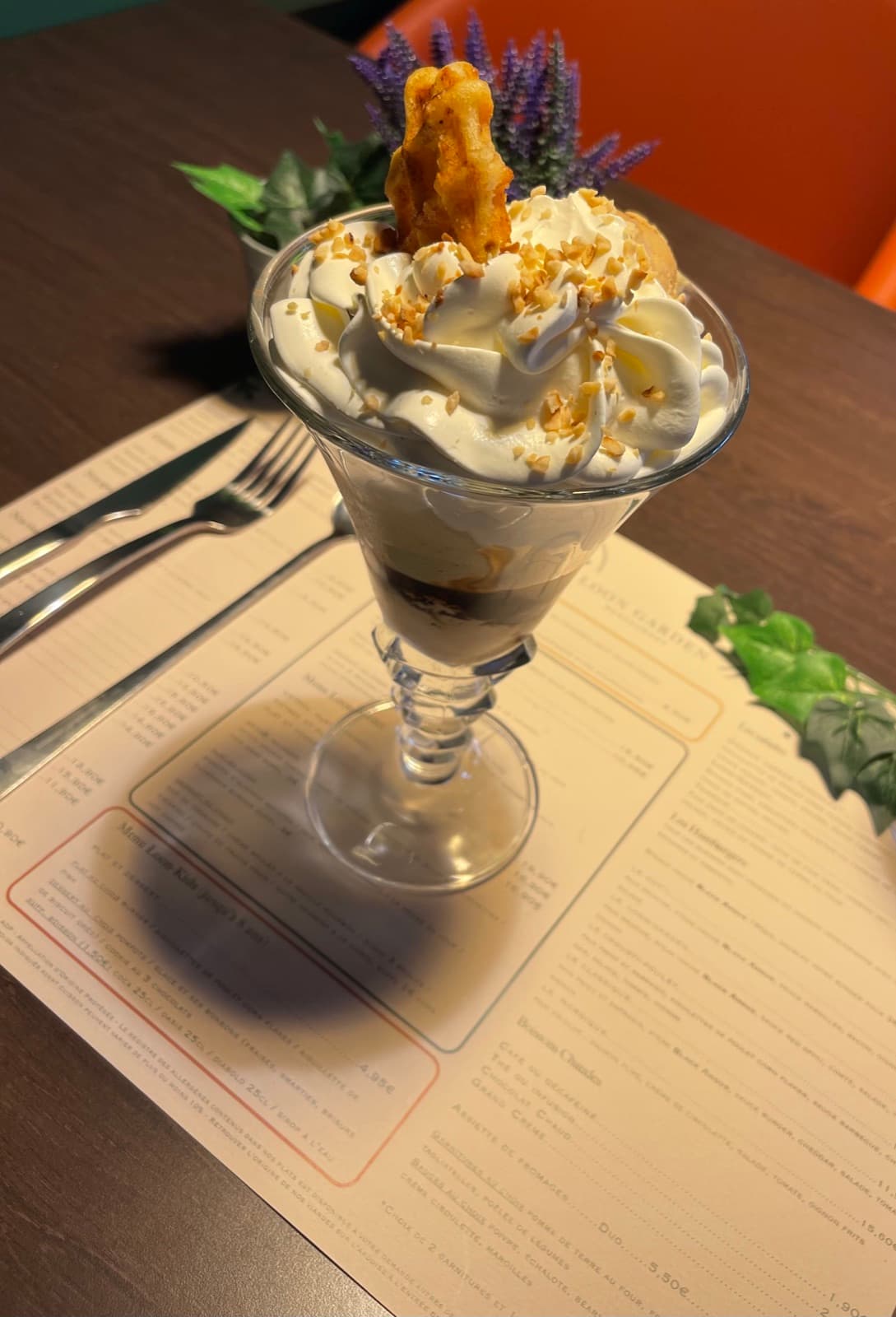 Ice cream sundae with whipped cream, hazelnut pieces and a wafer